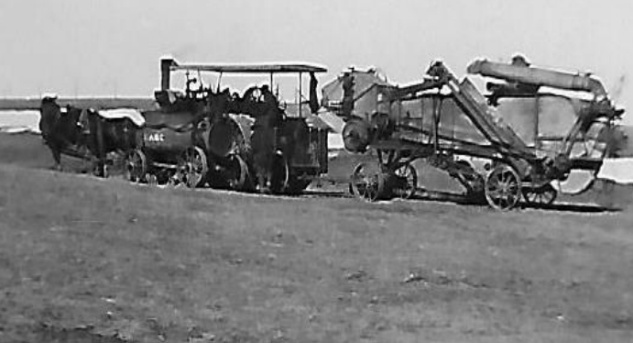 Steam tractor pulling threshing machine